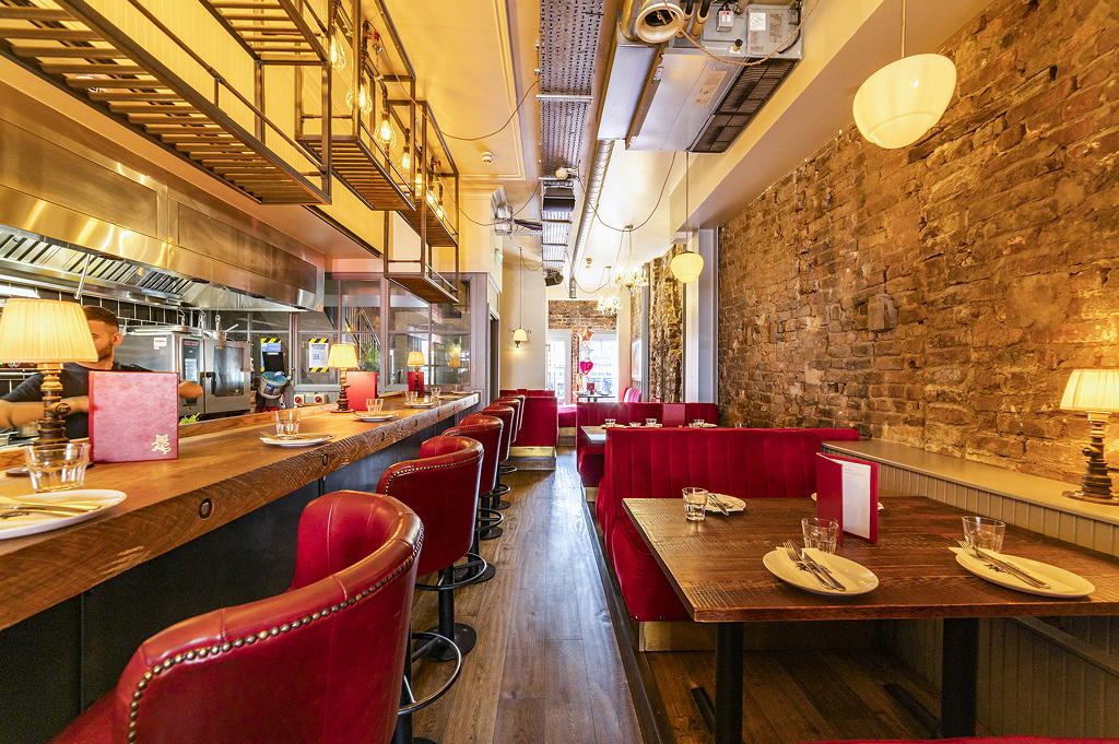 Red leather booths and exposed brick at El Gato Negro, Manchester